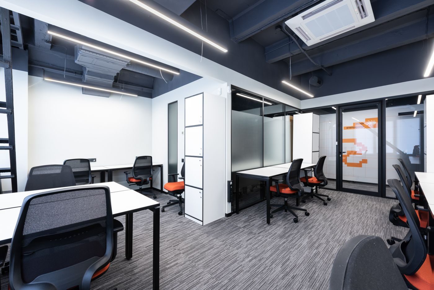 Modern open plan office with a ceiling cassette air conditioning unit above the desks